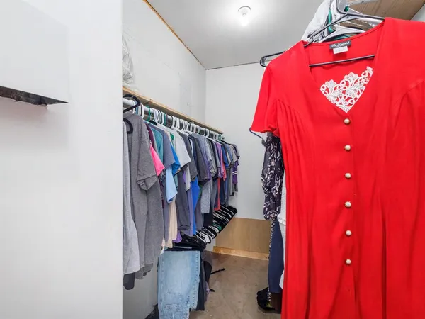 a view of walk in closet with clothes and shoes