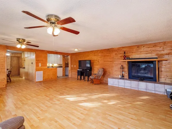 a view of a livingroom with a fireplace and a ceiling fan