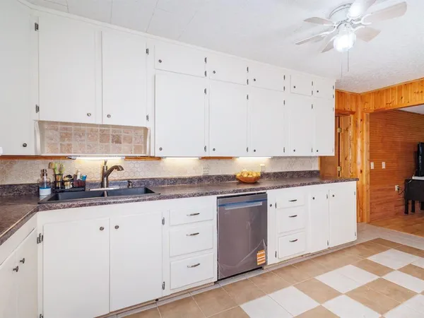 a kitchen with granite countertop white cabinets and stainless steel appliances
