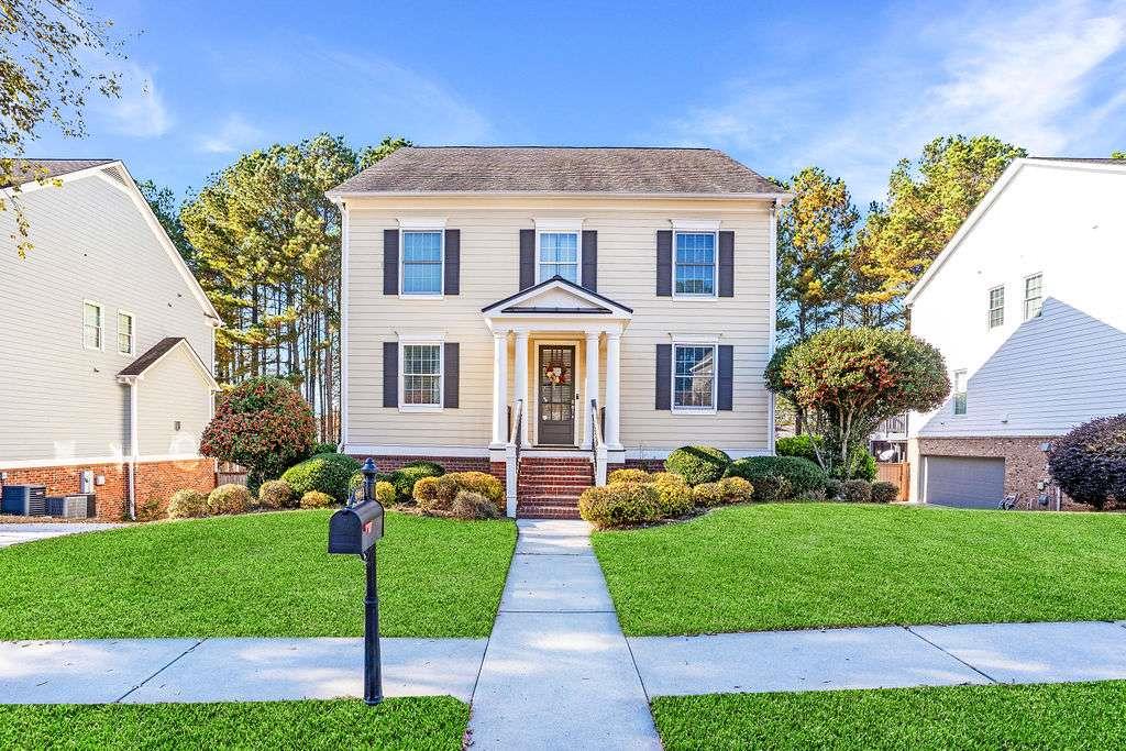 a front view of a house with a yard and potted plants