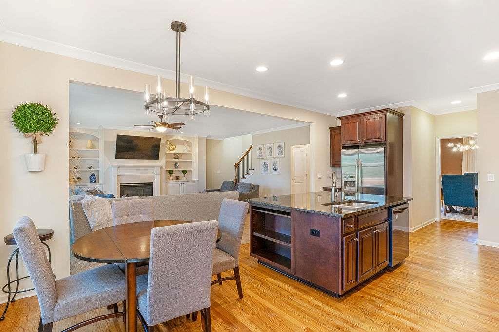 6463 Century Park Place Southeast Mableton, GA 30126 - Photo 17 of 42 a kitchen with stainless steel appliances granite countertop a stove top oven a sink dishwasher a dining table and chairs with wooden floor
