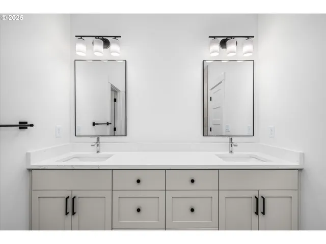 a bathroom with a double vanity sink mirror and