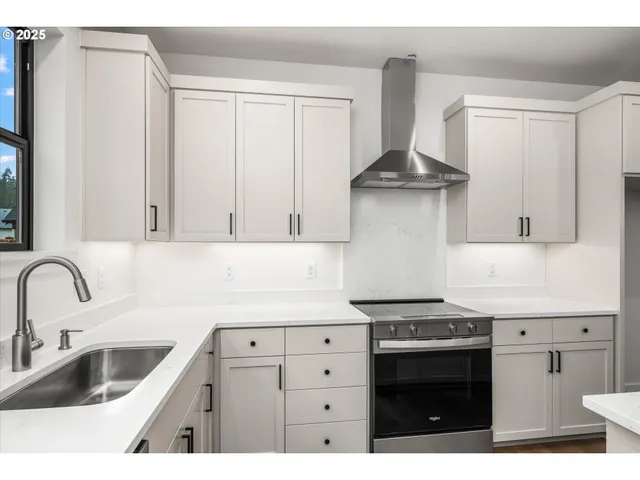 a kitchen with stainless steel appliances granite countertop a sink stove and cabinets