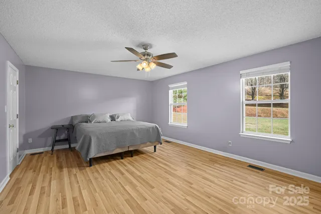 a bedroom with a large bed and a flat tv screen on a dresser