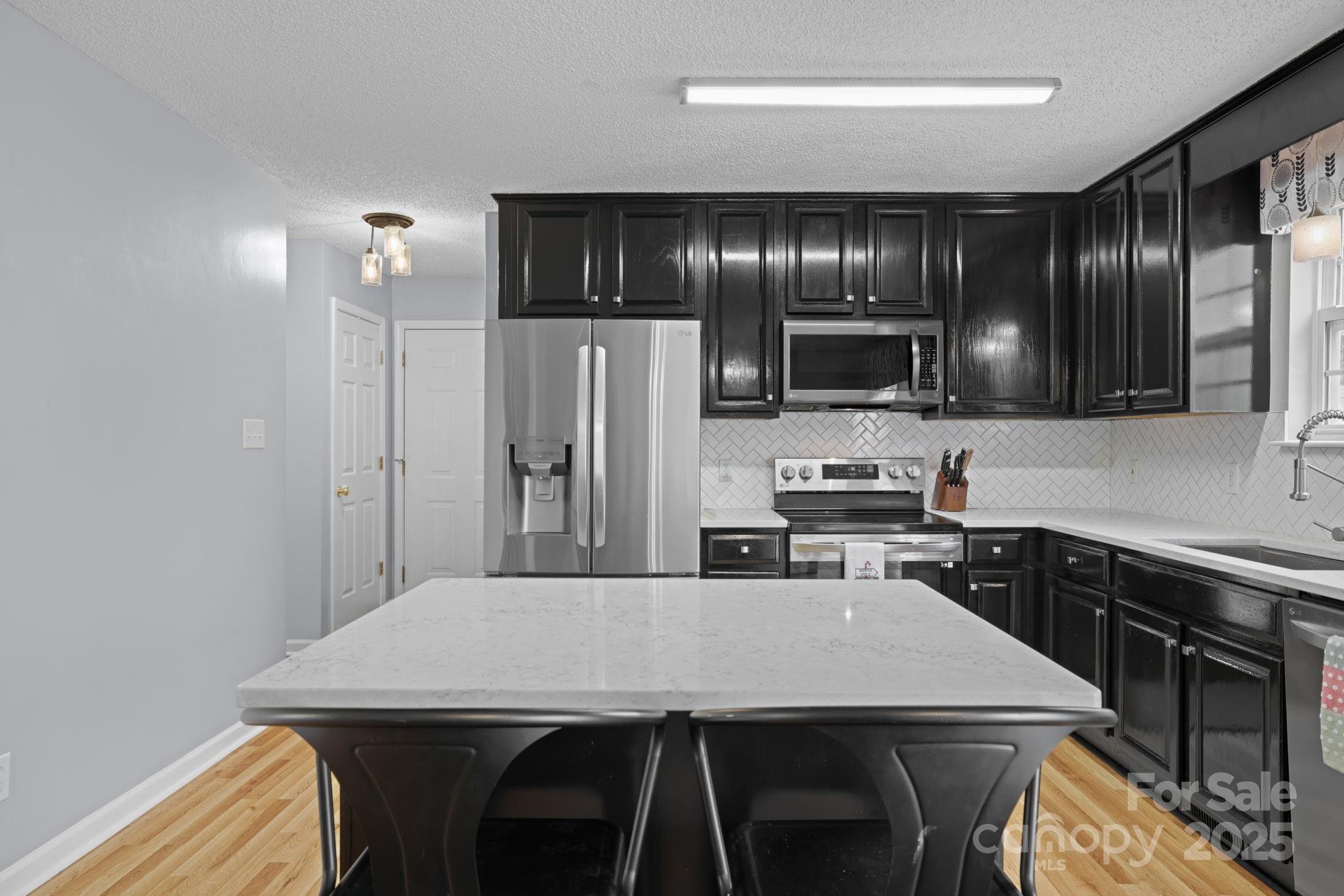 32 Wheat Ridge Road Sylva, NC 28779 - Photo 7 of 44 a kitchen with stainless steel appliances granite countertop a kitchen island a cabinets and wooden floor