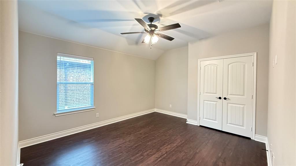 704 Ransom Way Greenville, TX 75402 - Photo 12 of 23 Unfurnished bedroom featuring dark wood-type flooring, a closet, and a ceiling fan