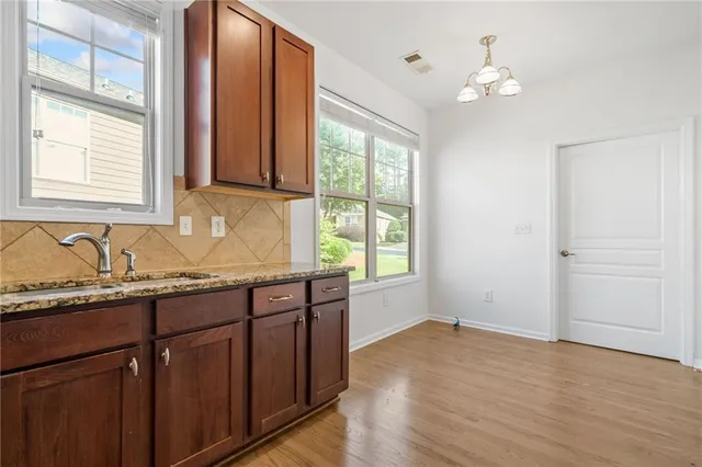 a bathroom with a granite countertop sink and a window