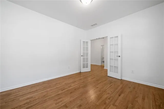 a view of an empty room with wooden floor