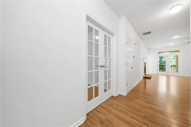 a view of a hallway with wooden floor and a living room