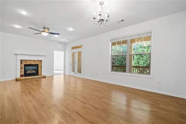 a view of an empty room with a window and fireplace