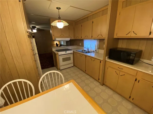 a kitchen with granite countertop a sink a stove and cabinets