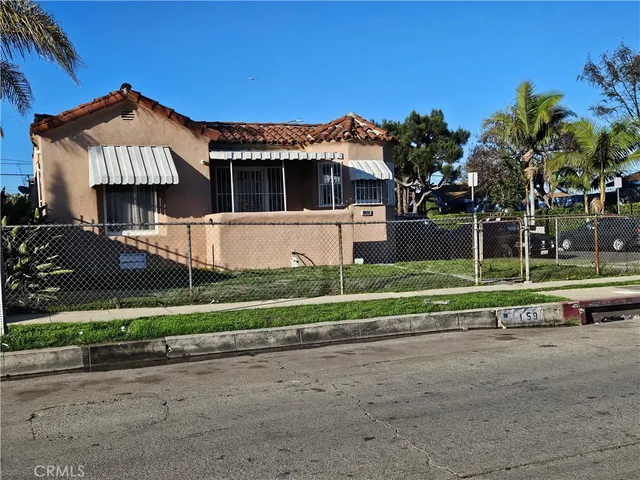 a front view of a house with a yard and potted plants