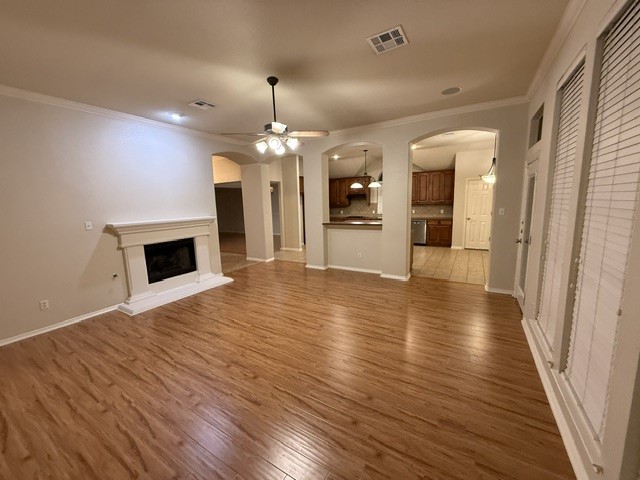 20724 Kearney Hill Road Pflugerville, TX 78660 - Photo 20 of 40 Spacious living area featuring wood-finish flooring, a white mantel fireplace, and a ceiling fan