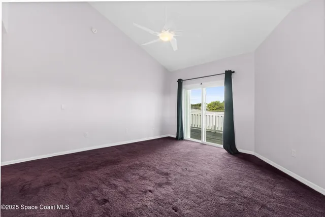 an empty room with wooden floor windows and cabinet