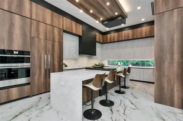a kitchen with stainless steel appliances granite countertop a sink a stove counter space and cabinets