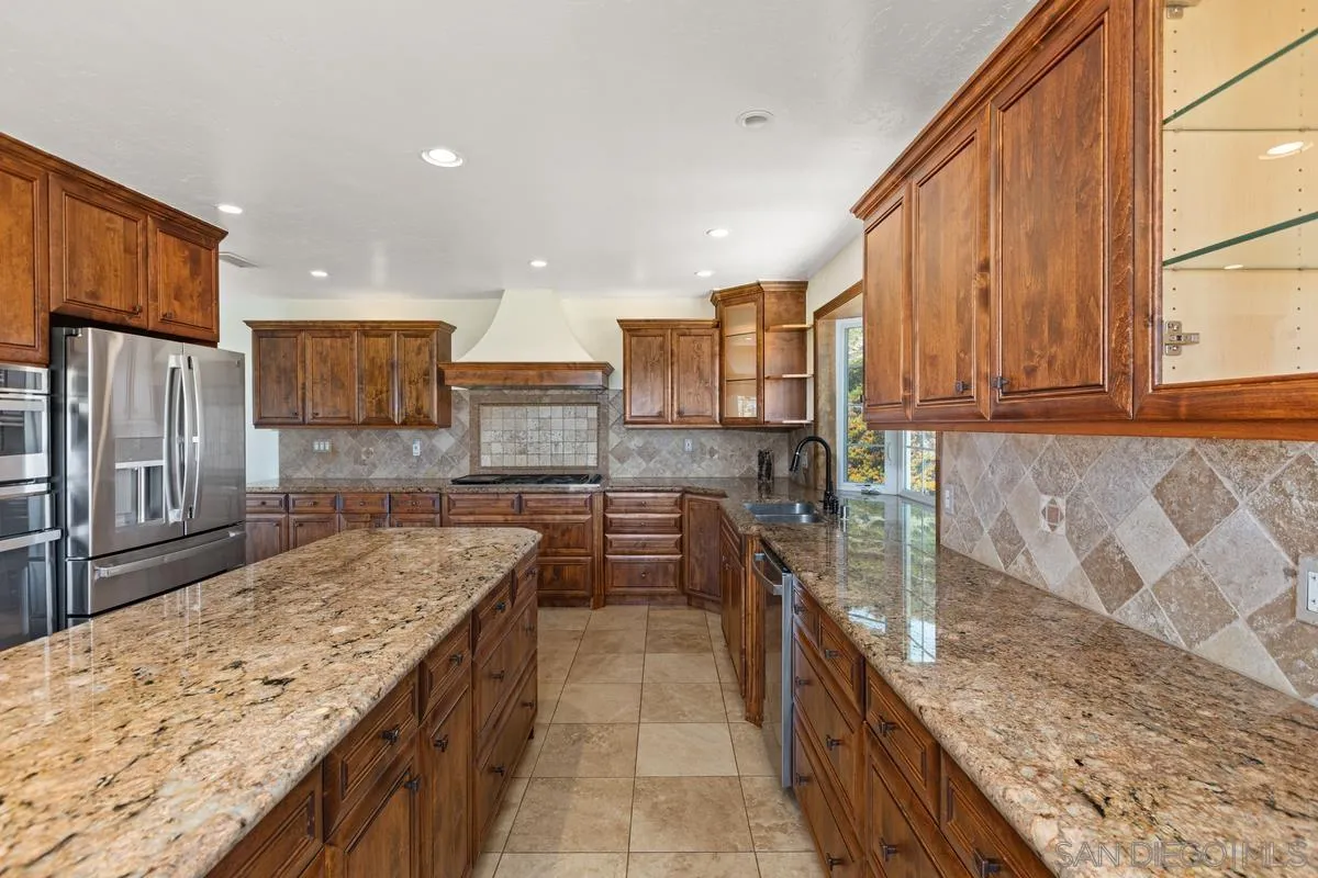 3049 Millar Ranch Road Spring Valley, CA 91978 - Photo 20 of 71 a kitchen with stainless steel appliances granite countertop a sink stove and refrigerator
