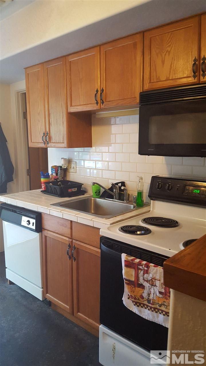 1120 Jones Street Reno, NV 89503 - Photo 18 of 25 a kitchen with stainless steel appliances granite countertop a stove a sink and a microwave