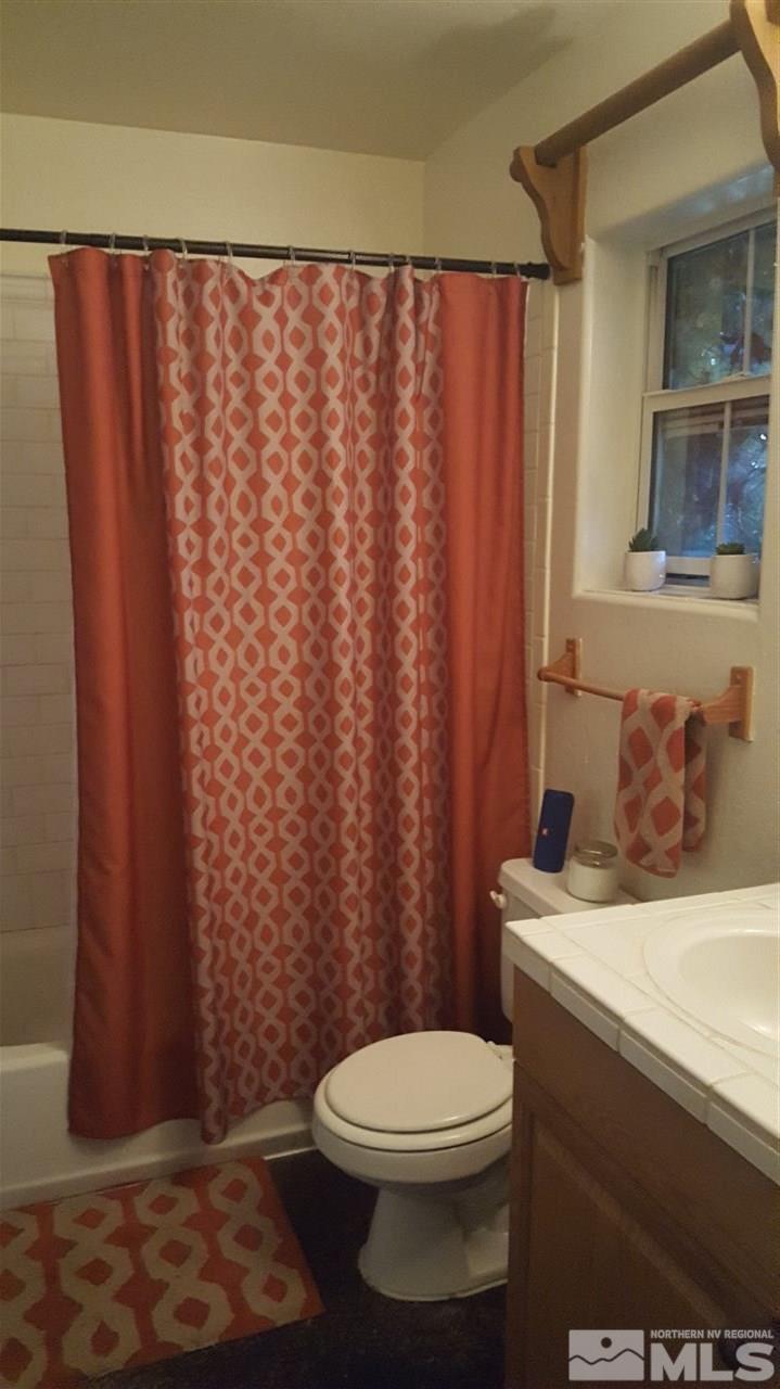 1120 Jones Street Reno, NV 89503 - Photo 21 of 25 a bathroom with a sink a toilet and shower curtain