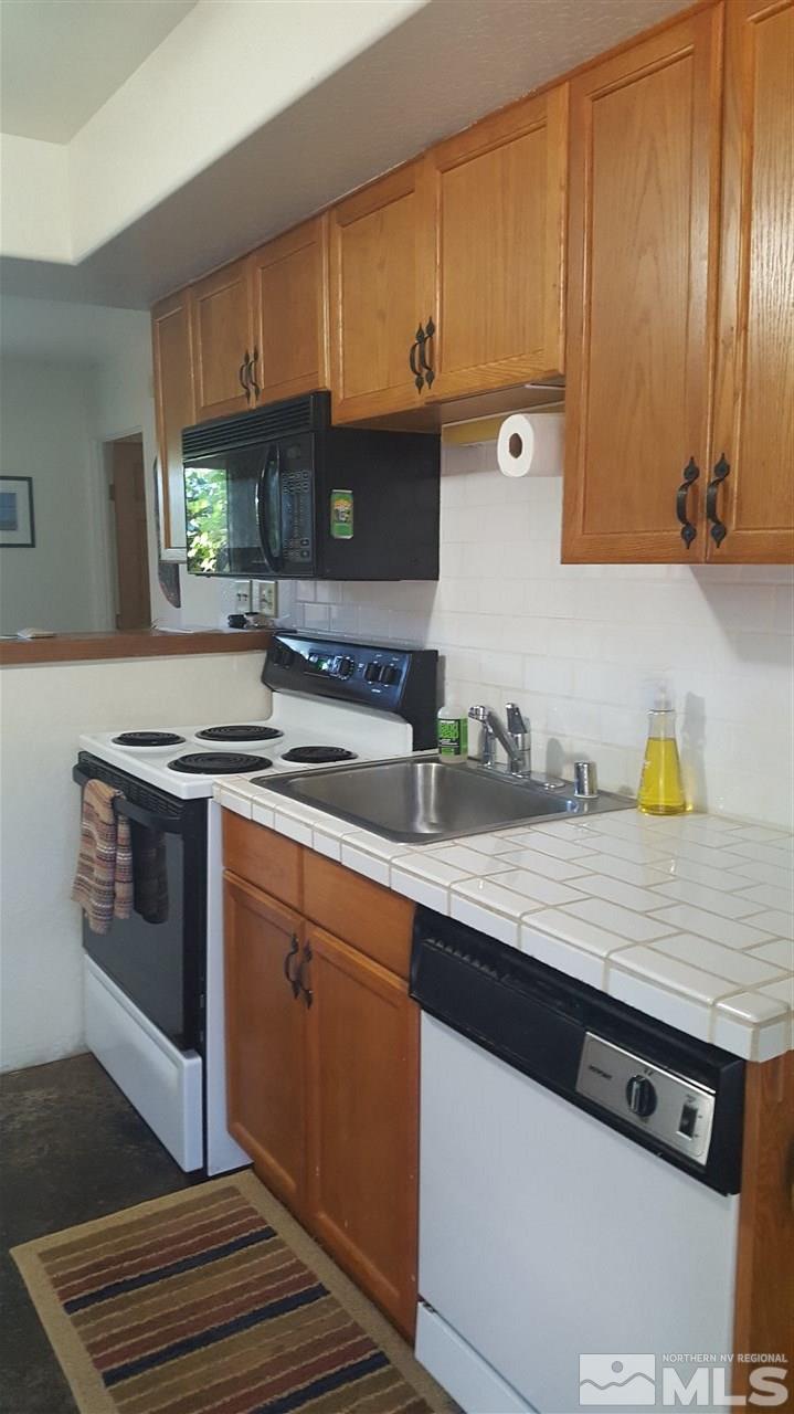 1120 Jones Street Reno, NV 89503 - Photo 22 of 25 a kitchen with stainless steel appliances granite countertop a sink stove and cabinets