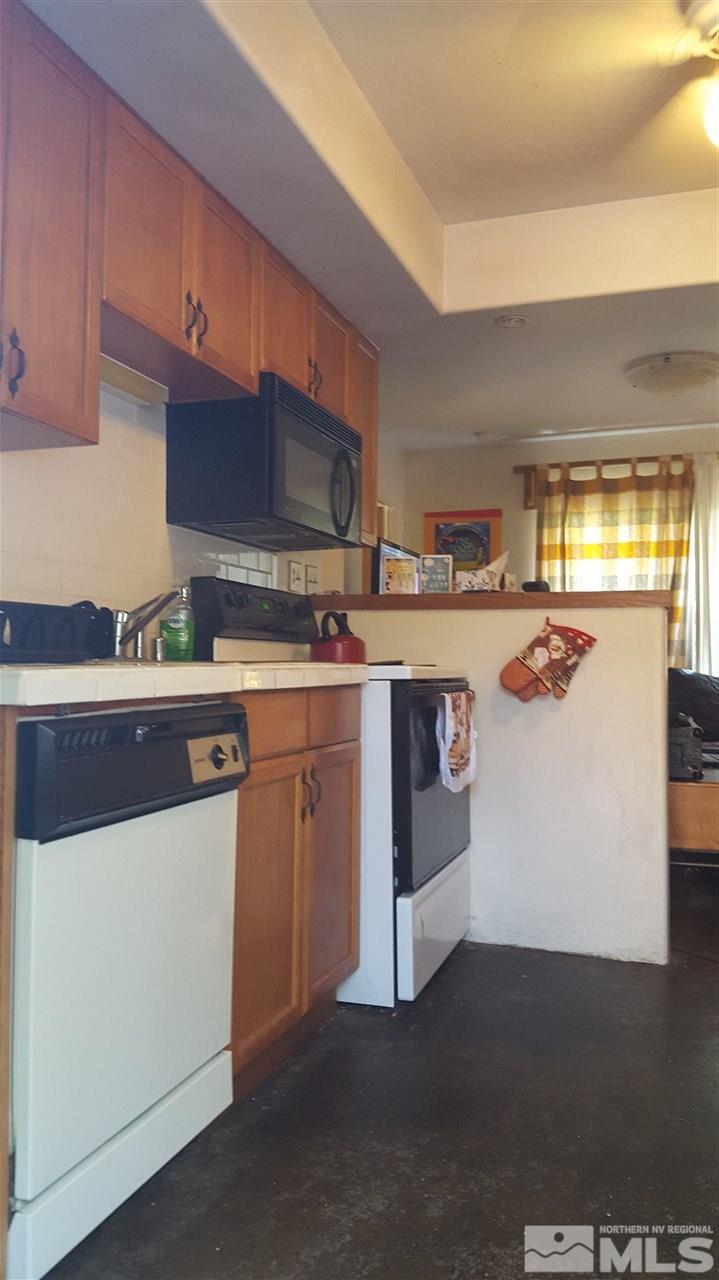 1120 Jones Street Reno, NV 89503 - Photo 23 of 25 a kitchen with stainless steel appliances granite countertop a stove a sink and a microwave