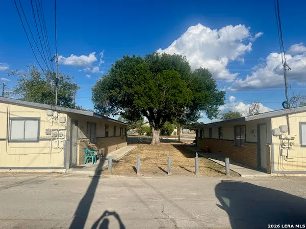a view of a backyard with table and chairs and wooden fence
