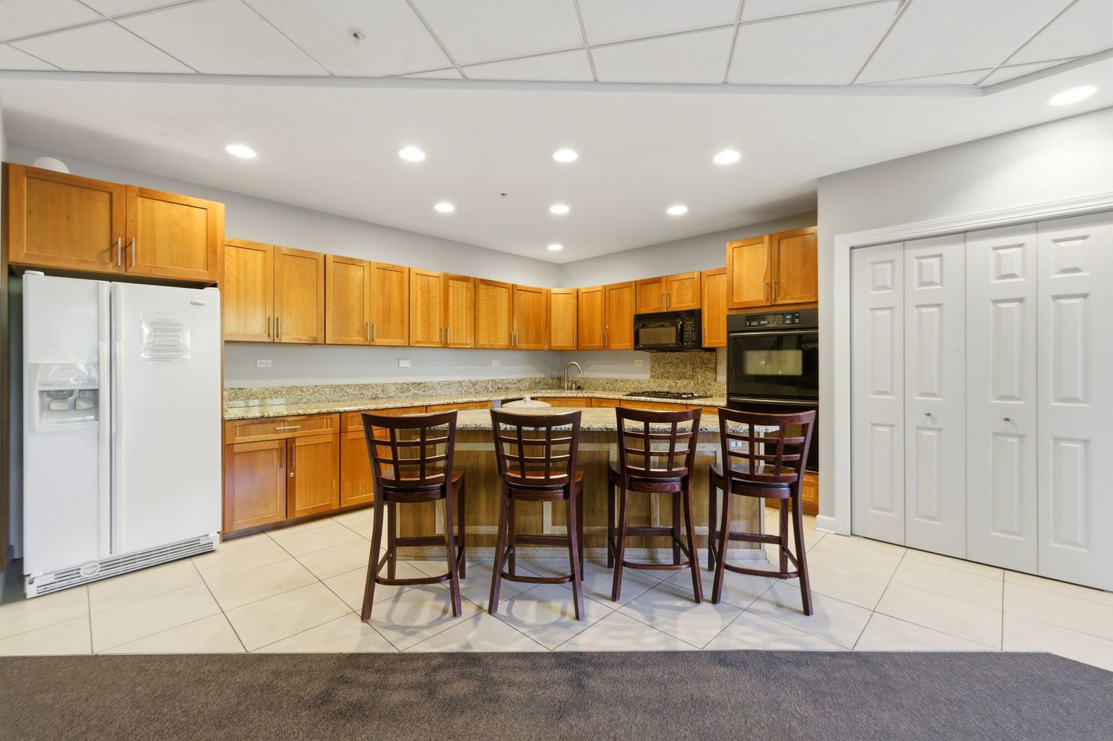 1 Renaissance Place, Unit 816 Palatine, IL 60067 - Photo 21 of 23 a kitchen with stainless steel appliances kitchen island granite countertop a refrigerator and cabinets