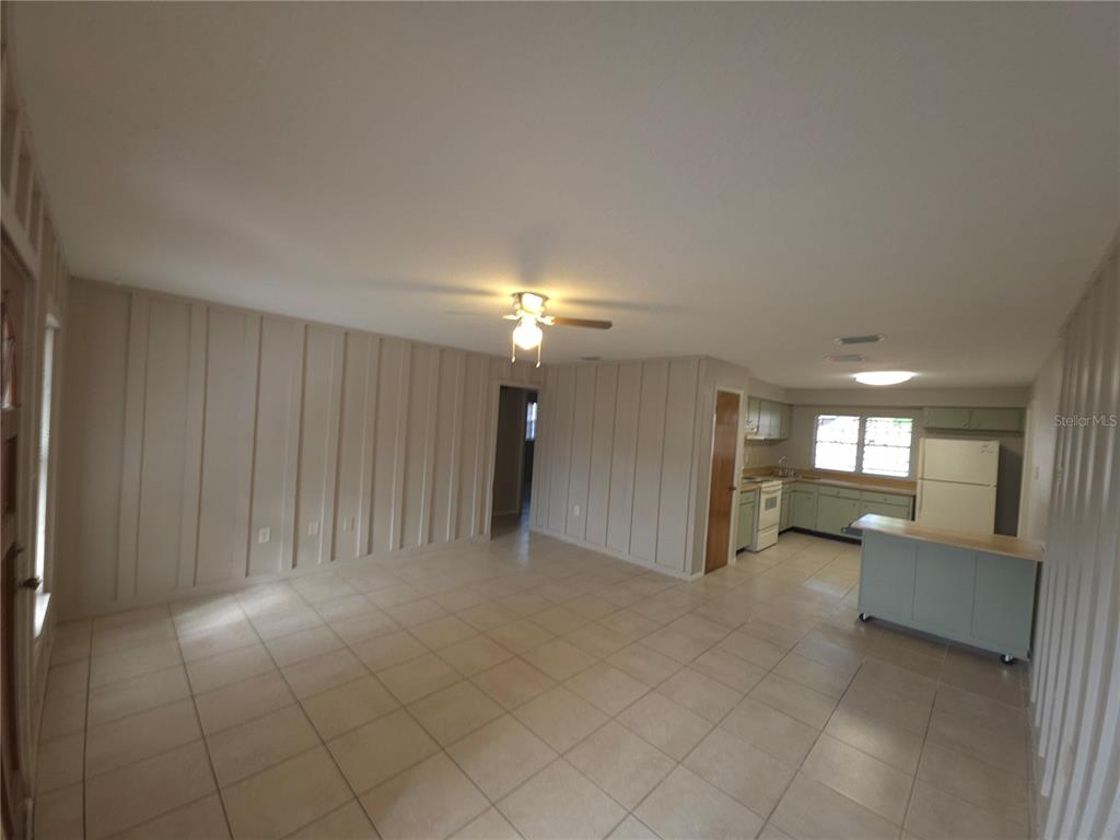 4204 East Okara Road Tampa, FL 33617 - Photo 5 of 21 an empty room with a kitchen and natural light
