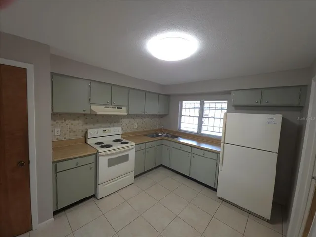 a kitchen with a cabinets and white appliances