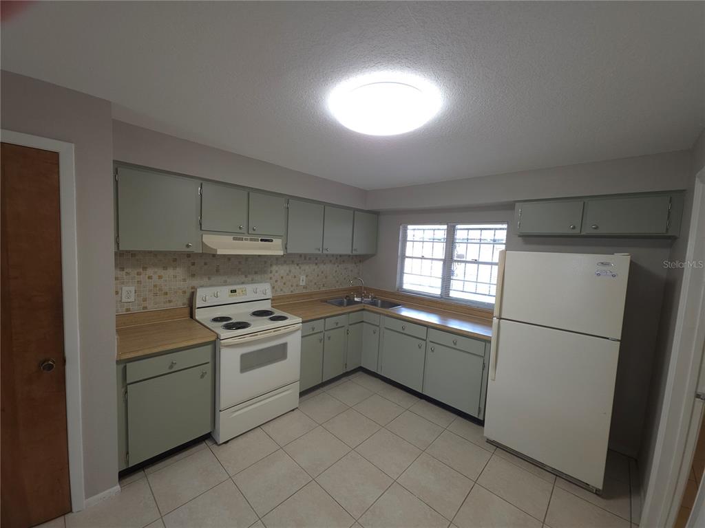 4204 East Okara Road Tampa, FL 33617 - Photo 7 of 21 a kitchen with a stove sink and refrigerator