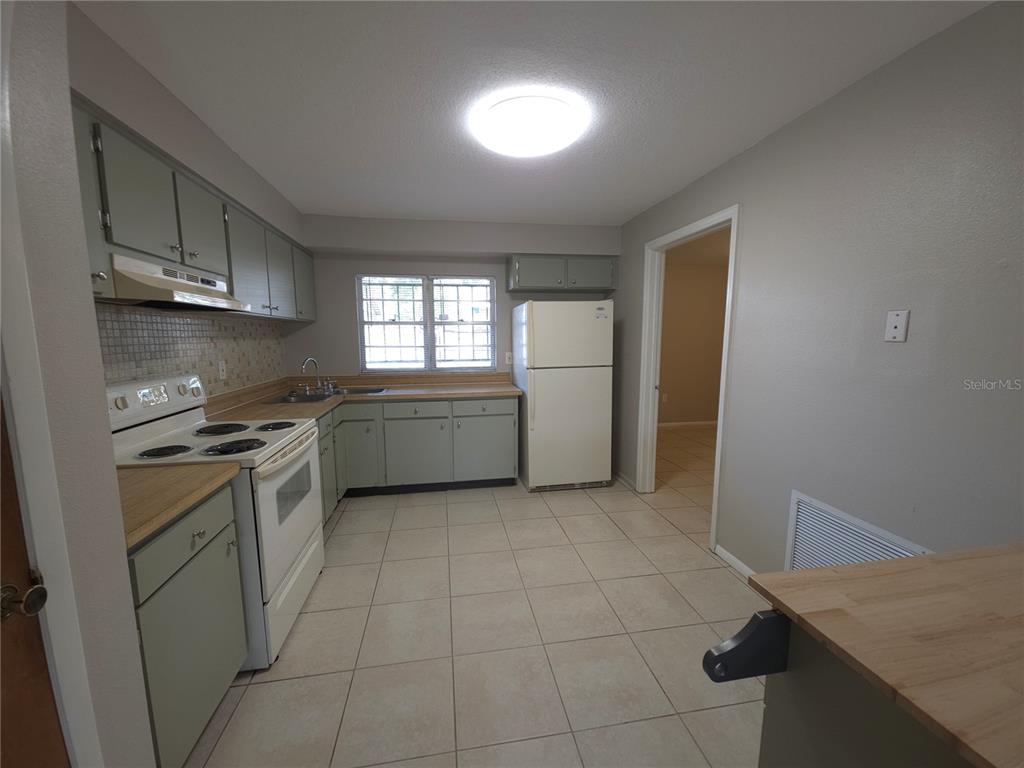 4204 East Okara Road Tampa, FL 33617 - Photo 8 of 21 a kitchen with a cabinets and white appliances