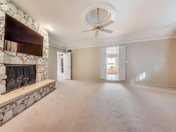 a view of empty room with fireplace and fan