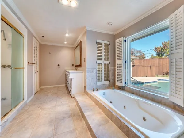 a bathroom with a tub a double vanity sink and mirror