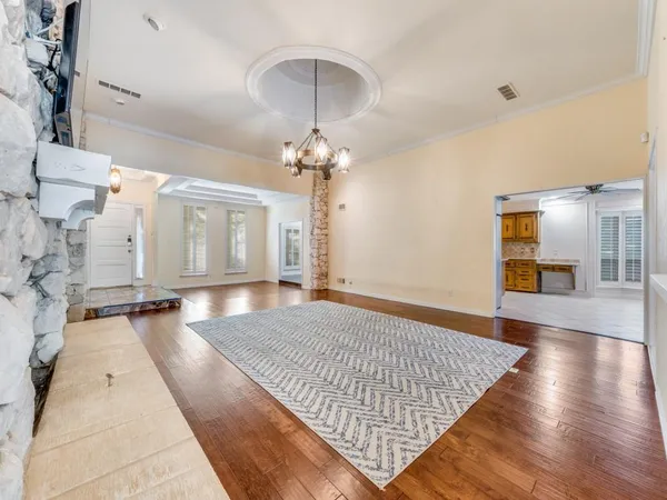 a spacious bedroom with a large bed and a chandelier