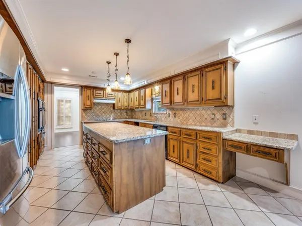 a kitchen with stainless steel appliances granite countertop a stove a sink and a refrigerator