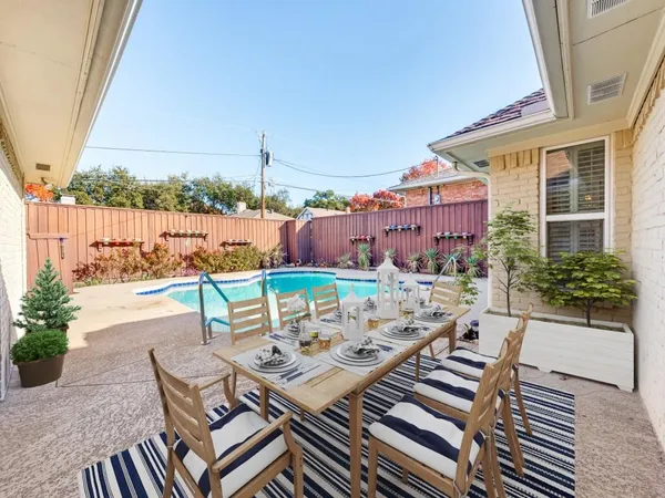 a view of a patio with table and chairs and potted plants