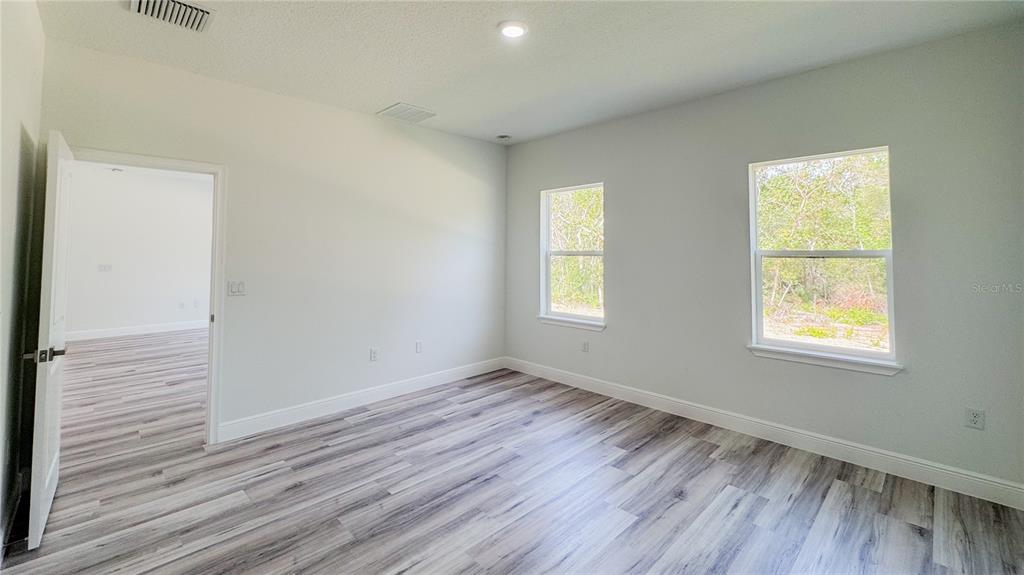 15625 Southwest 37th Circle Ocala, FL 34473 - Photo 23 of 27 an empty room with wooden floor and windows