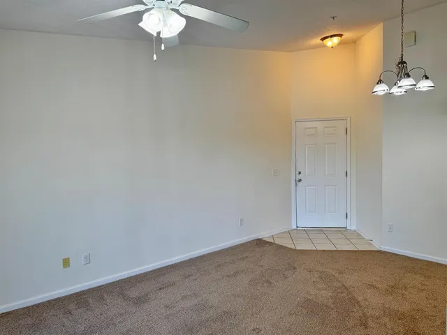 an empty room with a chandelier fan