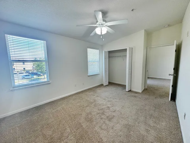 an empty room with fan and windows