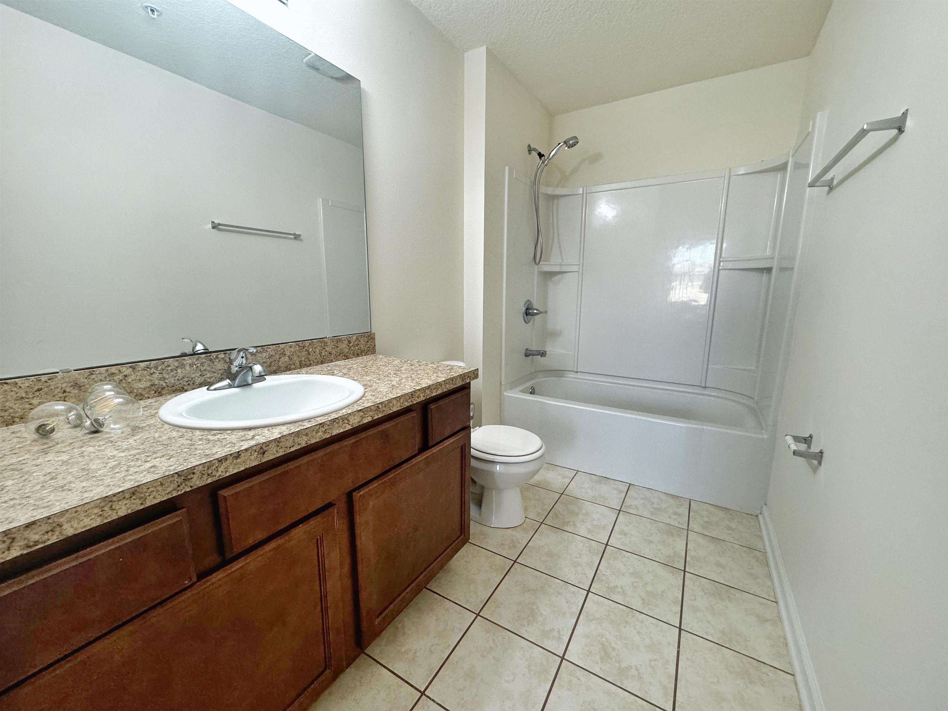2261 Golden Lake Loop St. Augustine, FL 32084 - Photo 24 of 43 a bathroom with a granite countertop sink a toilet a mirror and shower