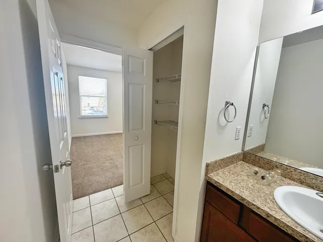 a bathroom with a granite countertop sink a mirror and a shower