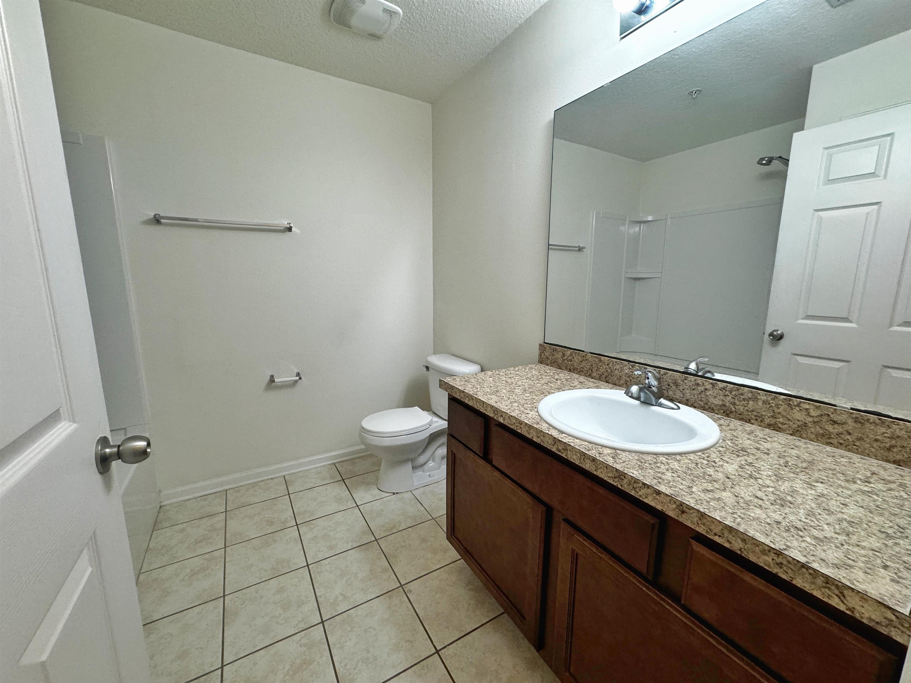 2261 Golden Lake Loop St. Augustine, FL 32084 - Photo 33 of 43 a bathroom with a granite countertop sink a toilet and a mirror