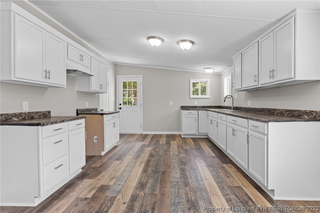 1770 Ashemont Road Aberdeen, NC 28315 - Photo 9 of 29 a kitchen with granite countertop white cabinets and white appliances