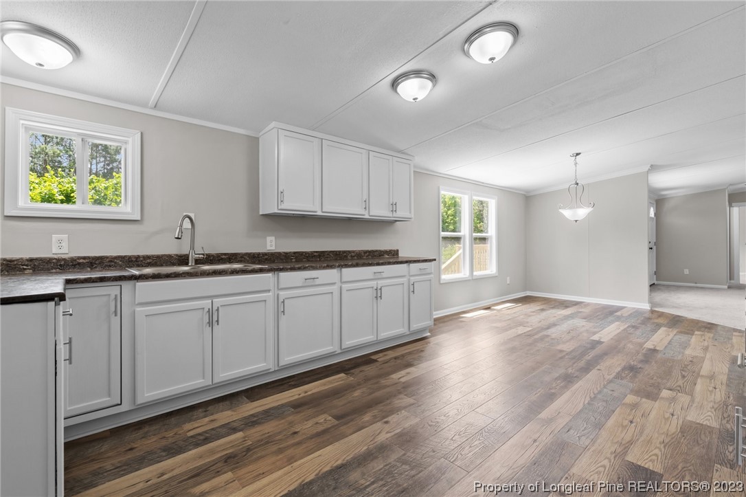 1770 Ashemont Road Aberdeen, NC 28315 - Photo 10 of 29 a kitchen with granite countertop a stove a sink and white cabinets