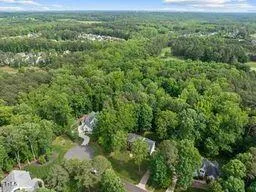 a view of a lush green forest with trees and some houses