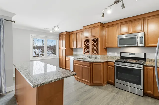 a kitchen with stainless steel appliances granite countertop a stove a sink and a microwave