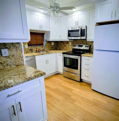 a kitchen with stainless steel appliances granite countertop a stove a sink and a microwave
