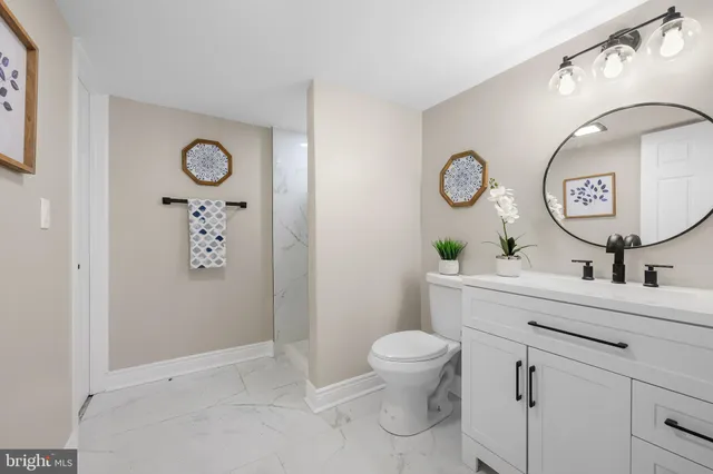 a bathroom with a toilet sink vanity and mirror