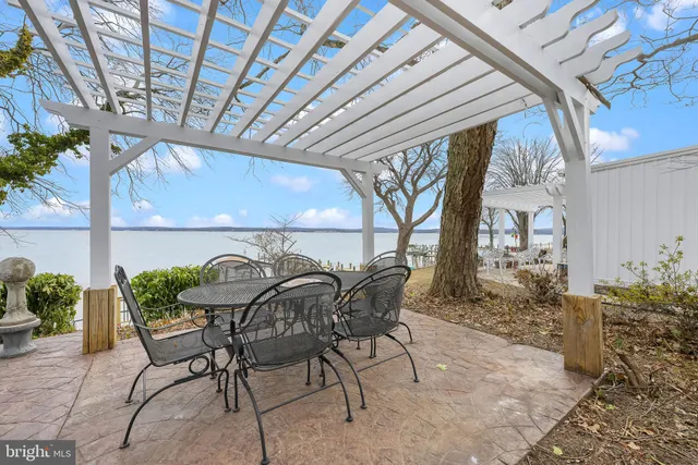 a patio with table and chairs and potted plants