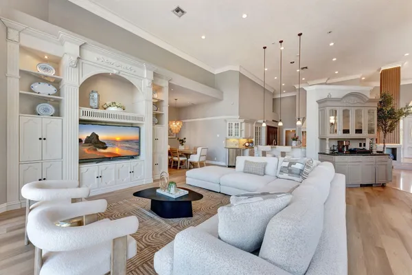 a kitchen with stainless steel appliances kitchen island granite countertop a stove a sink a dining table and chairs with wooden floor