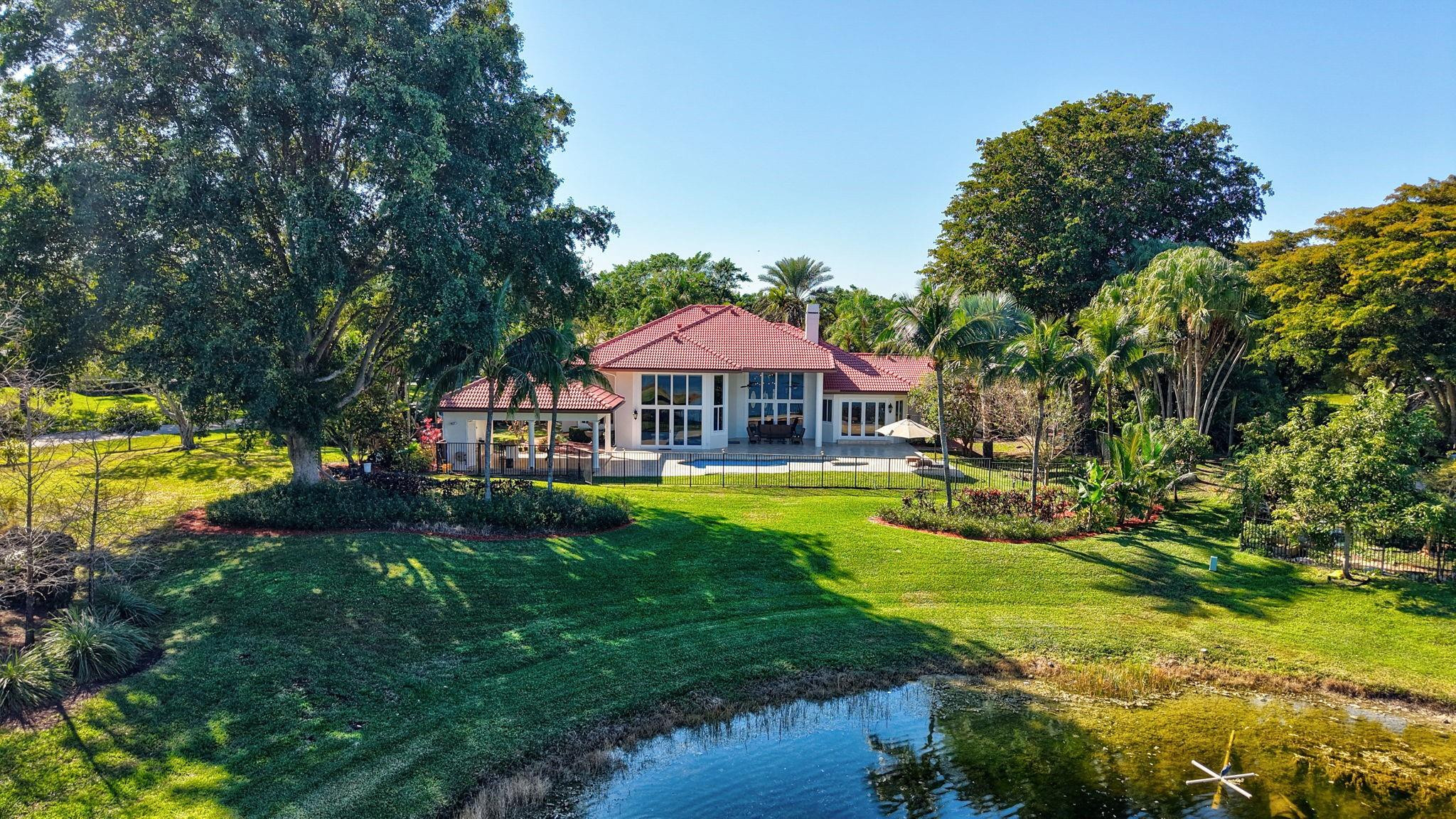 3460 Windmill Ranch Road Weston, FL 33331 - Photo 2 of 75 a front view of a house with swimming pool having outdoor seating